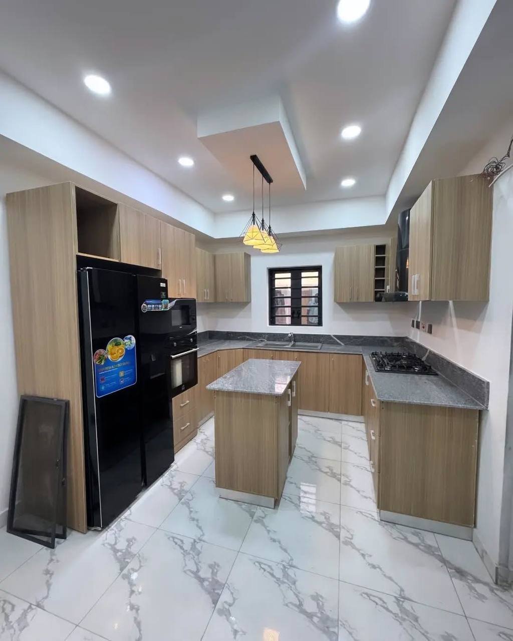 Cuisine sur mesure moderne laquée avec îlot central réalisée à Cocody, Abidjan